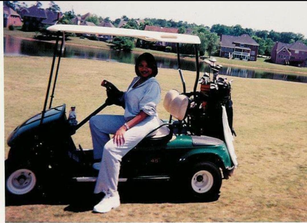 A woman sitting in the back of a golf cart.