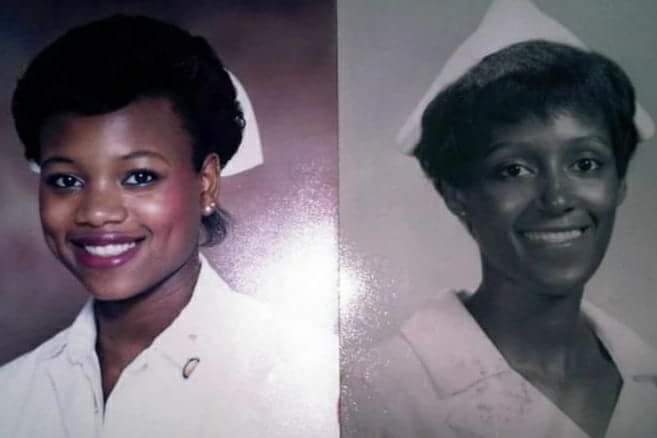 Two women in white uniforms smiling for a picture.